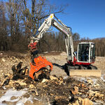 Weißer Bagger mit oranger Spaltzange